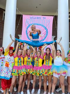 a group of women standing next to each other in front of a sign