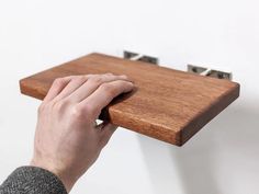 a person is holding onto a wooden shelf