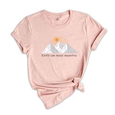 a women's pink shirt with the words faith can move mountains on it and a mountain