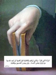 a person holding a book in their left hand with an arabic writing on the right