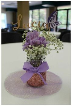 a vase filled with purple flowers and baby's breath on top of a table