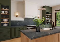 a kitchen with green cabinets and marble counter tops, along with an island in the middle