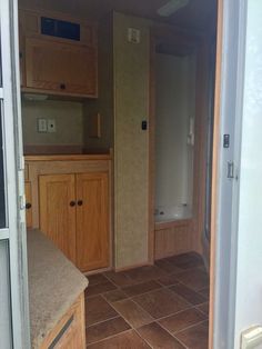 the inside of an rv with wood cabinets and tile flooring