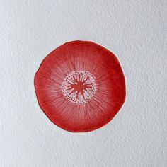 a piece of paper that has a red circle on it with a white flower in the center