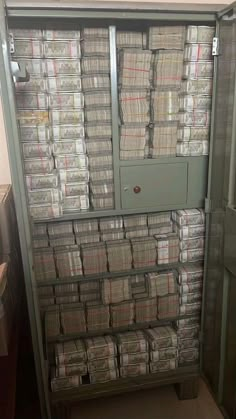 a large cabinet filled with lots of papers next to a wall covered in stacks of folders