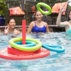 three girls in the pool playing with rings and o - rings on an inflatable raft