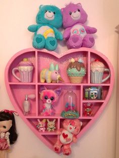 a pink heart shaped shelf filled with lots of stuffed animals and other toy stuff items