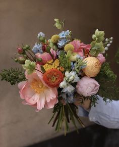 a person holding a bouquet of flowers in their hand