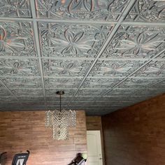 a room with wood paneling and chandelier hanging from the ceiling next to two exercise bikes