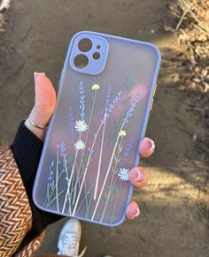 a person holding up a phone case with flowers on the front and back cover in their hand