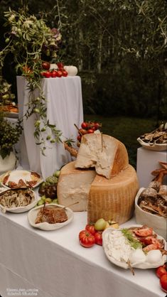 a table topped with lots of different types of cheeses and other foods on top of it