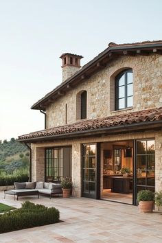 a large stone house with an outdoor seating area