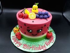 a birthday cake decorated with fruit and decorations