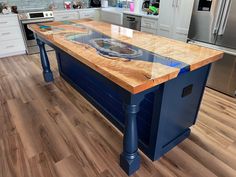 a kitchen with an island in the middle and stainless steel appliances on the other side