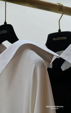 two shirts hanging on a clothes rack, one black and one white with the word valentine's day written on it