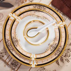 a white and gold plate with two forks on top of it next to a napkin