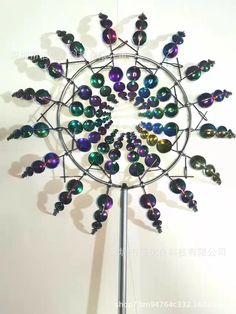 a metal clock with many different colored beads on it