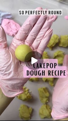 a person in pink gloves is making dough with yellow icing on the counter top