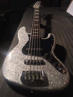 a black and silver guitar sitting on top of a table