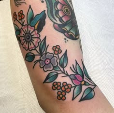 a woman's arm with flowers and butterflies on it