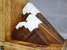 a wooden clock with white mountains on it