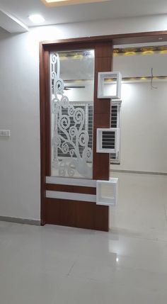 an empty room with white tile floors and wooden doors that have decorative designs on them