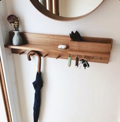 a coat rack with umbrellas and keys hanging from it's hooks in front of a mirror