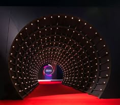 a red carpeted area with lights in the center and a black wall behind it