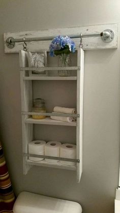 a white toilet sitting in a bathroom next to a shelf