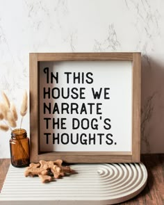 a wooden frame sitting on top of a table next to a jar filled with peanuts