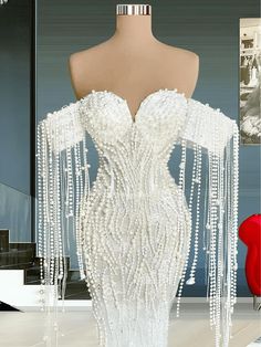 a mannequin with white beaded dress on display