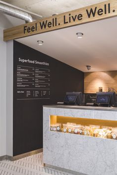 the front desk of a well - lit restaurant with an information board above it that says, feel well live well