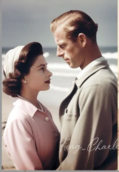 a man and woman standing next to each other near the ocean