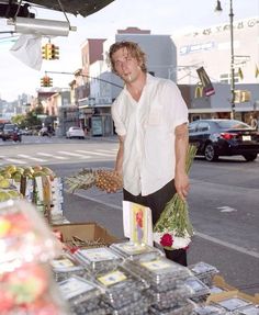 a man standing in front of a fruit stand