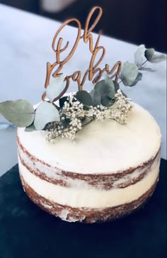 a cake with white frosting and greenery on top