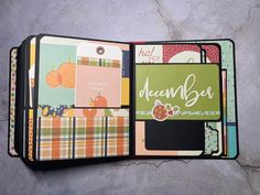 an open scrapbook with many different papers on it, including pumpkins and plaid