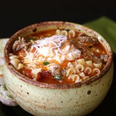 a bowl of pasta soup on a black plate