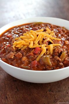 a white bowl filled with chili and cheese