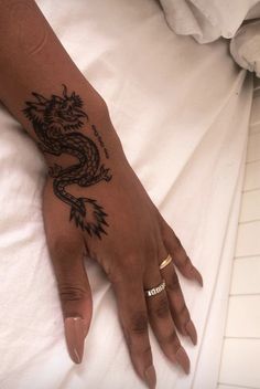 a woman's hand with a dragon tattoo on it