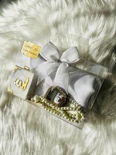 a box with some jewelry on it sitting on a white fur covered floor next to a pair of scissors