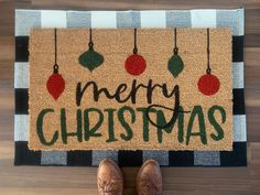 someone standing in front of a merry christmas door mat