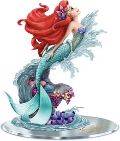 the little mermaid figurine is on display