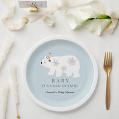 a white plate with a polar bear on it next to some forks and napkins