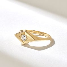 The Rhombus Northstar Signet Ring is a petite and elegant piece of jewelry that blends celestial motifs with geometric design. Crafted from high-quality 14k solid gold, this ring features a unique rhombus-shaped signet adorned with a small, sparkling diamond in the center. Features * Made to Order. * Gold KT: 10K, 14K, 18K * Width of Band: 1.87MM * Width of Top: 8.06x13.68MM * Thickness of Band: 1.31MM * Custom Gold Color: Rose Gold, Yellow Gold, White Gold * Diamond Color- Clarity: D-E-F color VVS clarity (excellent ideal cut) *Total Ctw: 0.12 ctw * Ready to Ship in 5-7 Business Days ✓ We care about the environment,the jewelry we cast is made with recycled gold. We source exclusively post-consumer material that is refined back to their pure elements to ensure that the gold is in the same Celestial Single Diamond Wedding Jewelry, Celestial Wedding Jewelry With Single Diamond, 14k Gold Celestial Diamond Ring, Celestial 14k Gold Diamond Ring, Celestial Single Diamond Ring Gift, Celestial Single Diamond Promise Ring, Celestial Style Single Diamond Ring As Gift, Celestial Style Single Diamond Promise Ring, 14k Gold Single Diamond-shaped Jewelry