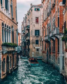 a narrow canal in venice, italy with boats on the water and buildings lining both sides