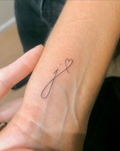 a woman's arm with a tattoo on it that has a knife and heart