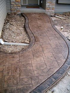 a brick walkway in front of a house that is being built into the side of a building