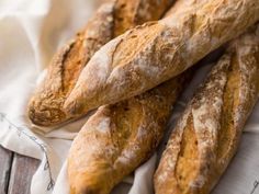 three loaves of bread sitting on top of a white cloth