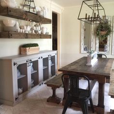 a dining room table with chairs and shelves on the wall