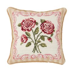 a cross stitched pillow with roses on the front and back, in pink tones